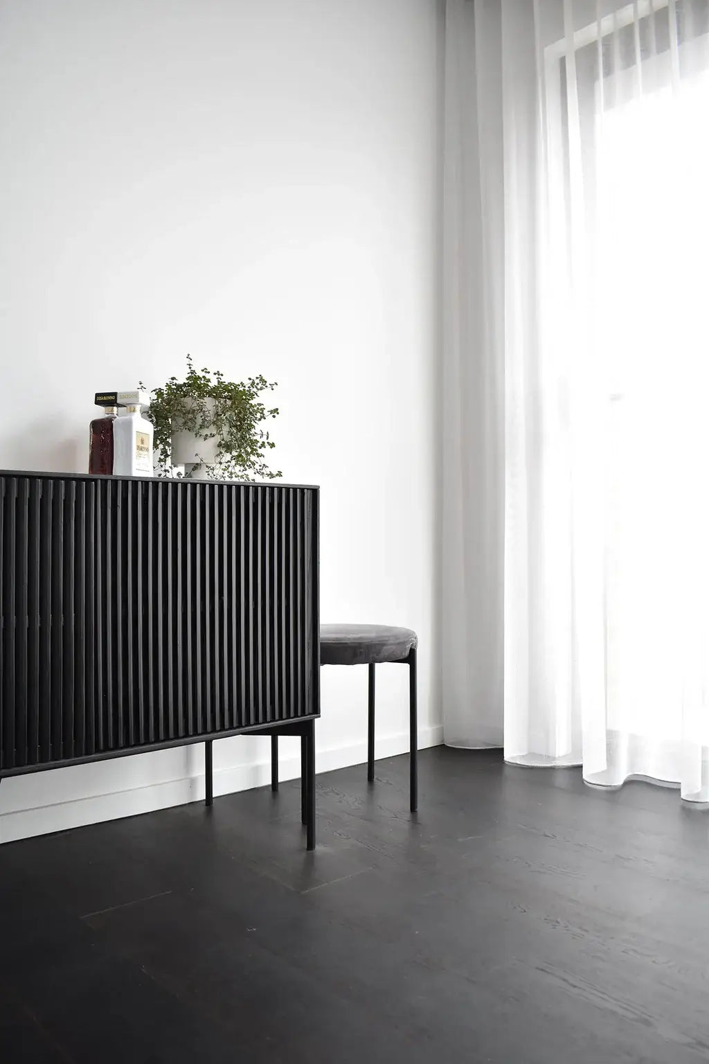 Modern interior with a black radiator and white curtains
